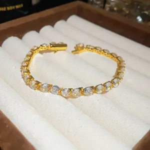 Primo piano di un elegante bracciale in zirconi placcato oro 18k su vassoio
