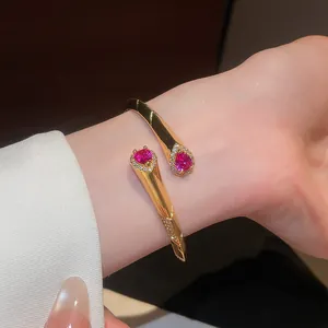 Dettaglio di bracciale rigido placcato oro 18k con zirconi rosa a forma di goccia