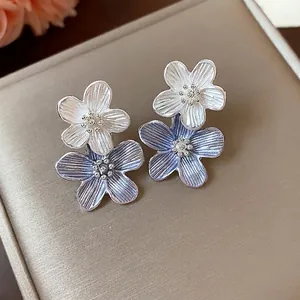 Elegante silberne Blumenohrringe mit weiß-violetten Emaille-Blütenblättern.