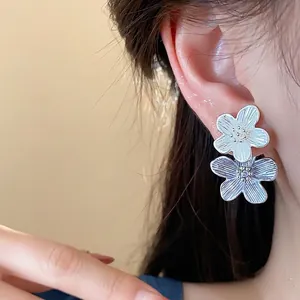 Elegante Doppelblumen-Ohrstecker mit weißen und lila Emaille-Blütenblättern für Damen.