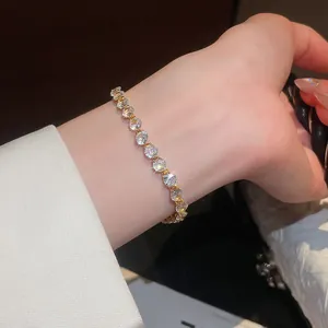 Bracciale tennis in zirconi scintillanti placcato oro 18 carati al polso, vista dettagliata.