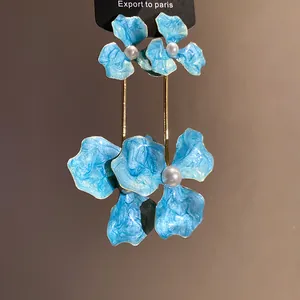 Elegante blaue Emaille-Blumenohrringe mit weißen Perlenmitten in der Nahaufnahme