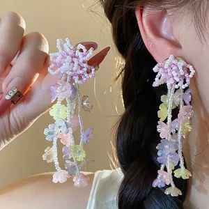 Elegant colorful glass beaded flower tassel earrings shown being worn by a model