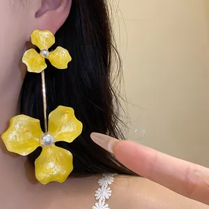 Detailansicht großer gelber Emaille-Blumenohrringe mit Perle am Model