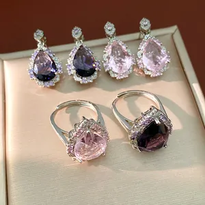 Detailed close-up view of pear-cut purple and pink zircon jewelry set on a tray.