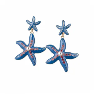 Eleganti orecchini a goccia a stella marina blu con strass rosa e perle su sfondo bianco