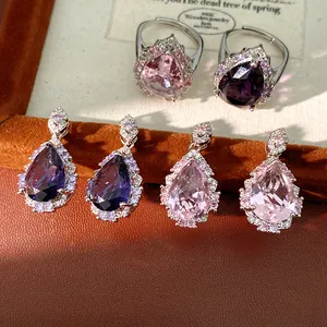 Detail view of vintage teardrop zircon earrings and rings set in pink and purple