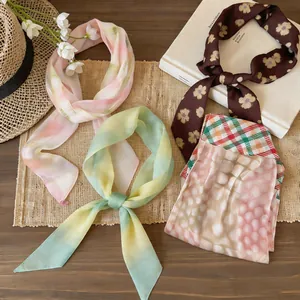 Vista dettagliata di vari foulardi in chiffon con motivi floreali e sfumati