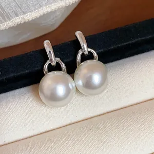 Primo piano di eleganti orecchini di perle tonde con finitura argento su velluto
