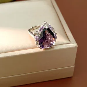 Close-up of a vintage palace style ring with pear-cut purple zircon and halo stones