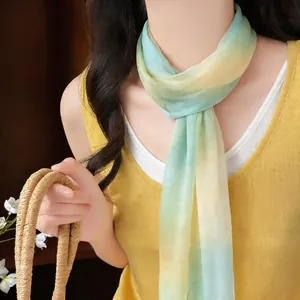 Vista dettagliata di un foulard in chiffon sfumato verde e giallo indossato al collo