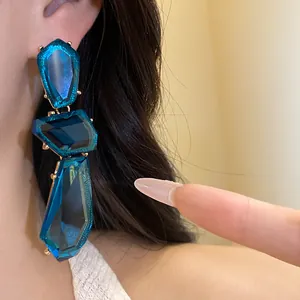 Dettaglio di orecchini pendenti in resina blu irregolare in stile vintage esagerato