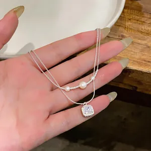 Elegante collana d'argento a due strati con pendente in zircone quadrato e perle bianche