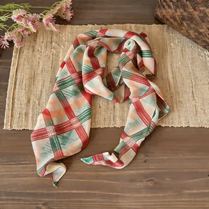 Primo piano del leggero foulard in chiffon a quadri rossi e verdi per l'estate calda