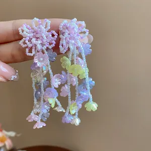 Exquisite macro detail of colorful glass beaded flower stud earrings with pastel drop charms