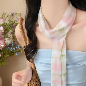 Vista dettagliata della texture di una sciarpa di chiffon a quadri pastello sul modello