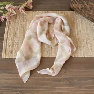 Dettaglio ravvicinato di sciarpa in chiffon a quadri con delicati toni rosa e verde