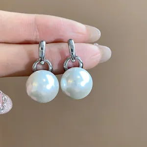 Primo piano di eleganti orecchini di perle tonde con finitura in argento lucido