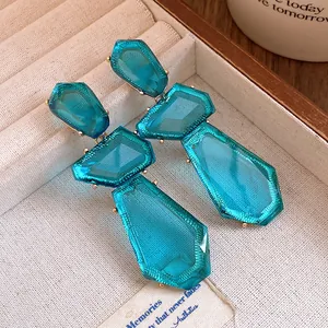 Dettaglio di orecchini pendenti vintage in resina turchese irregolare in vassoio