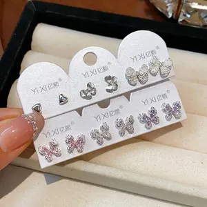 Elegantes Set mit Zirkonia-Schmetterlings- und Perlenohrsteckern auf Markenkarten