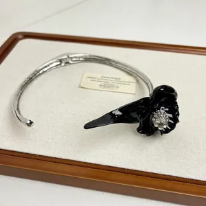 Vista dettagliata della collana vintage con iris in smalto nero e strass scintillanti