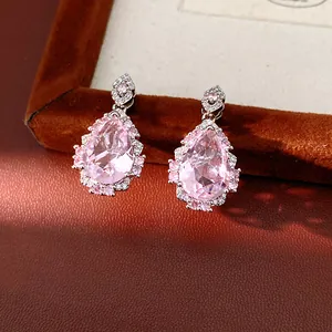 Macro view of elegant pink teardrop zircon earrings featuring palace style crystal settings