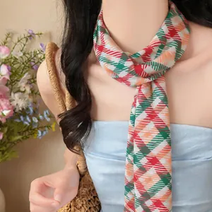 Vista dettagliata di una sciarpa in chiffon a quadri indossata come accessorio da collo