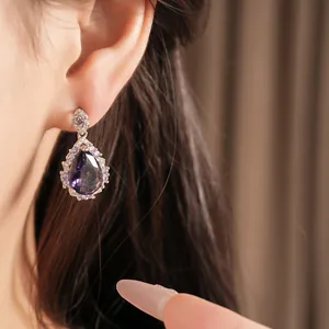 Exquisite close-up of palace-style waterdrop earrings with purple zircon worn by a model.