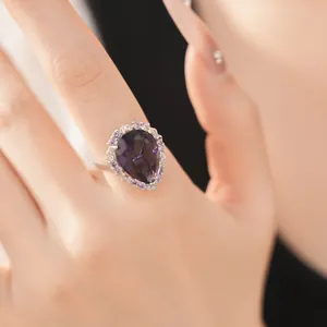 Close-up detail of a pear-shaped purple zircon ring with halo crystals