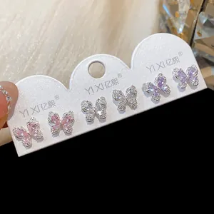 Detailansicht von Zirkon Schmetterling Ohrsteckern in Pink, Weiß und Lila.