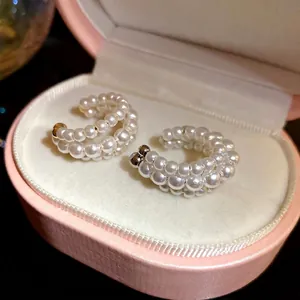 Vintage three-layer pearl beaded ear cuffs displayed in an elegant pink jewelry box