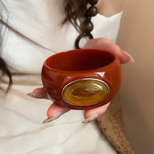 Detailed close-up of a vintage amber acrylic bangle featuring a large oval stone centerpiece
