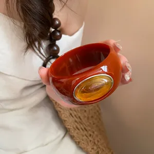 Detailed macro shot of vintage amber acrylic bangle with marbled oval resin inlay detail