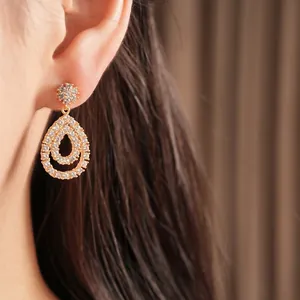 Elegante 18 Karat vergoldete Doppel-Wassertropfen-Ohrringe mit Zirkonia-Steinen am Model