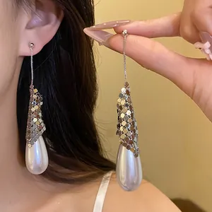 Elegant silver teardrop pearl earrings featuring detailed metallic mesh wrap and long chain