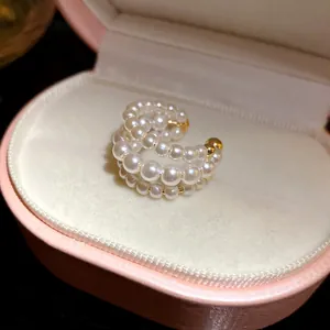 Macro detail of three-layer vintage pearl beaded ear cuff presented in pink box