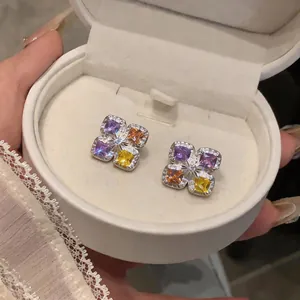 Vue détaillée de boucles d'oreilles fleurs avec des zircons carrés multicolores