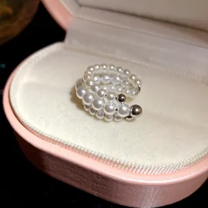 Close-up view of an elegant three-layer pearl beaded ear cuff in a pink jewelry box