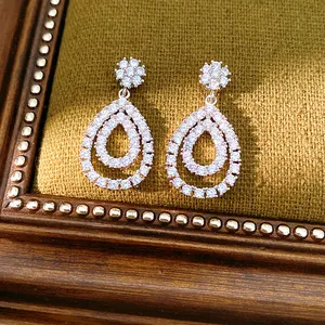 Nahaufnahme von tropfenförmigen Ohrringen mit schimmerndem Zirkonia-Pavé-Besatz.