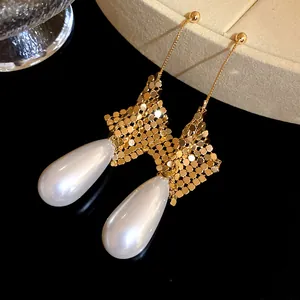 Detailed view of elegant gold mesh long drop earrings featuring lustrous white teardrop pearls