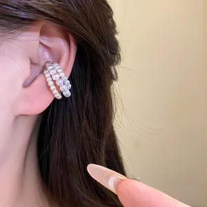 Detailed view showing the elegant triple-layer pearl beaded ear cuff worn on the ear
