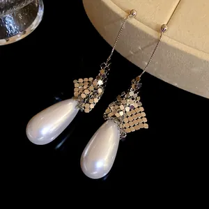 Detailed macro view of elegant silver water drop earrings featuring white pearls and mesh