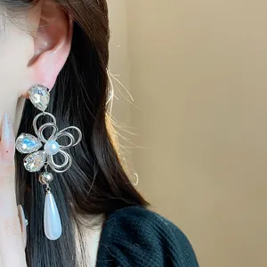 Close-up detail of exquisite 18k gold plated flower crystal and pearl drop earrings