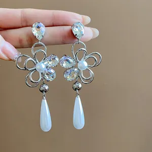 Macro view of exquisite silver flower earrings with crystal accents and pearl drops