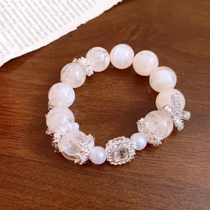 Dettaglio del bracciale di perle stile francese con perle di marmo bianco e fiocco.
