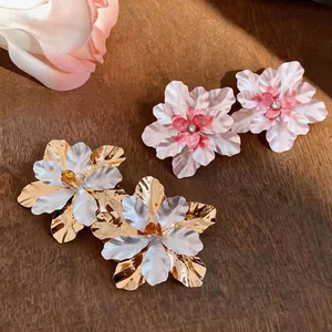 Elegant metal flower stud earrings with sparkling rhinestones and white enamel petals