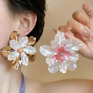 Macro view of oversized elegant metal flower earrings with delicate rhinestone details
