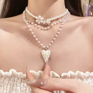 Detailed view of a retro multi-layer pearl necklace featuring a flower and heart pendant