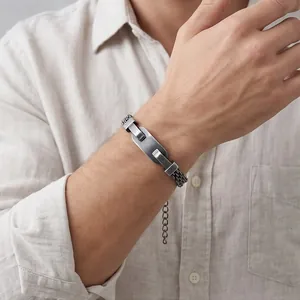 Close-up of a vintage stainless steel mesh bracelet with curved plate on a man's wrist