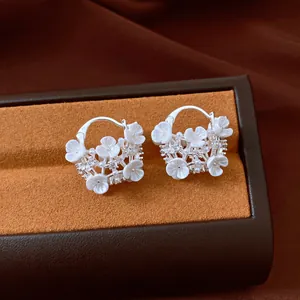 Detail view of elegant silver-colored flower basket earrings with pearls and crystals